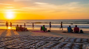 Cenário de praia no Nordeste durante pôr do sol, com pessoas aproveitando a onda calor persiste e clima agradável